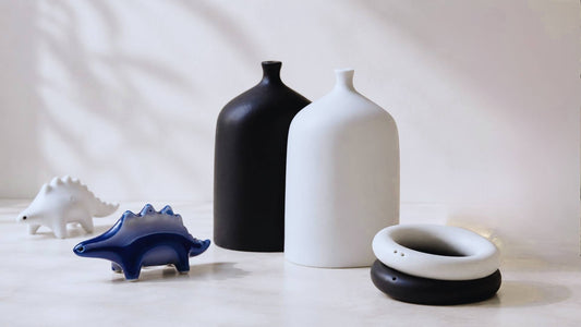 Unique black and white ceramic salt and pepper shakers displayed on a modern dining table with minimalist home decor.
