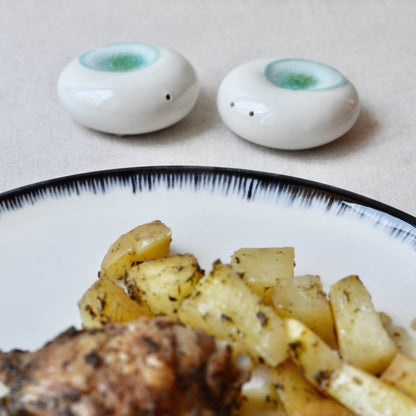 Modern minimalist porcelain salt and pepper set styled on a dining table, designer-grade high-fired porcelain by Maia Ming Designs. Handmade in Barcelona, ideal for boutique hotel decor, interior styling, or a thoughtful design lover gift.