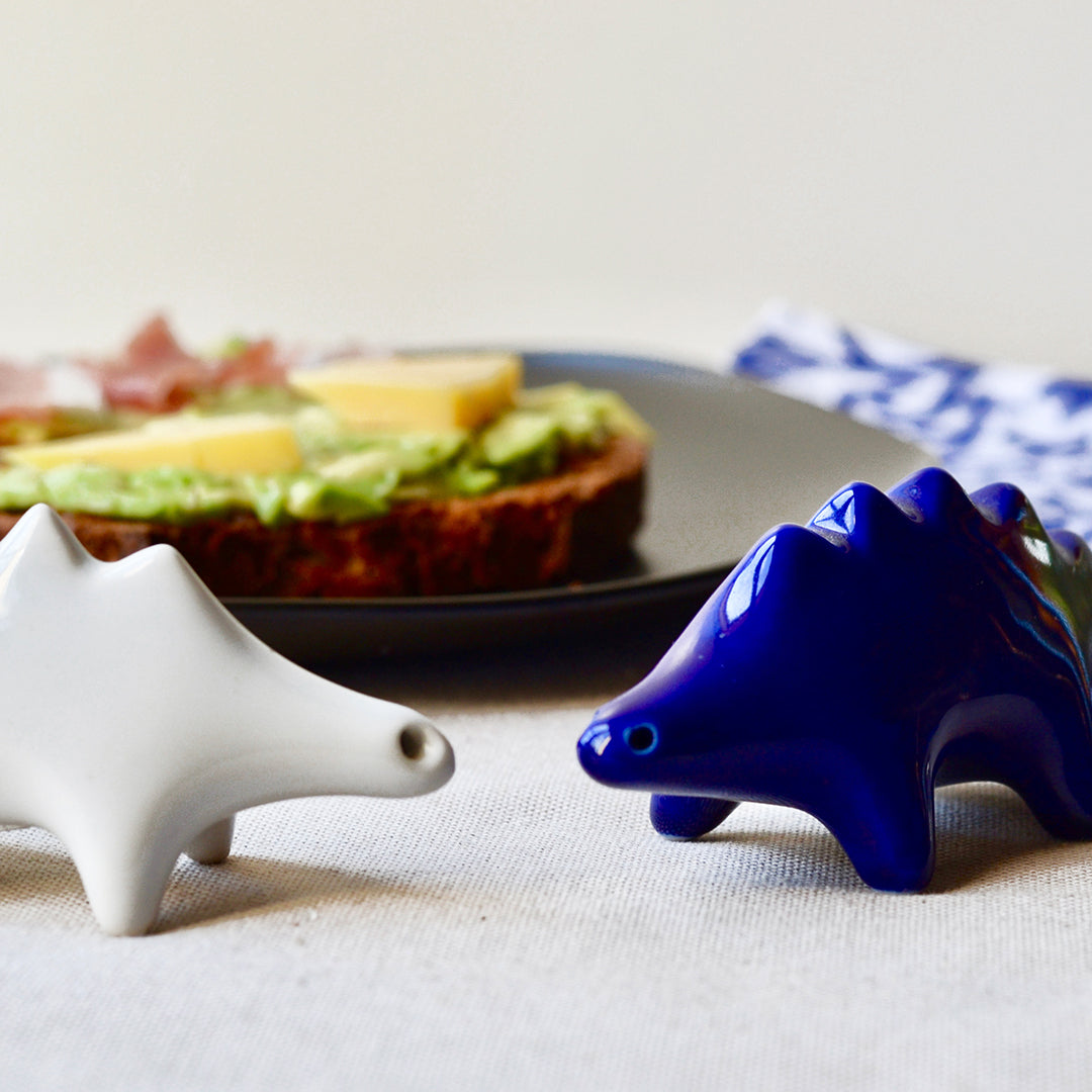 Modern minimalist dinosaur salt and pepper set in designer-grade porcelain by Maia Ming Designs, a playful yet refined table accent. High-fired and food-safe artisan pottery from Barcelona, perfect for design lovers, thoughtful gifts, or boutique hotel decor.